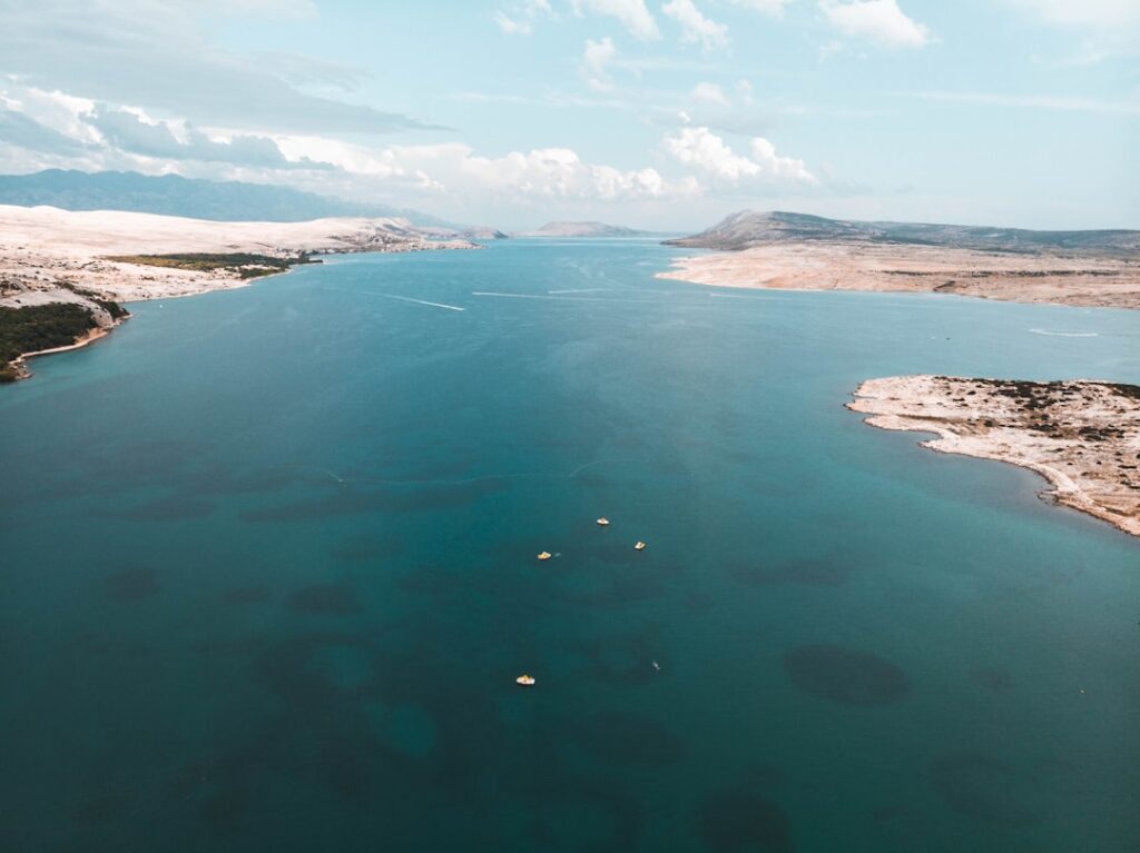 body of water near mountain during daytime
