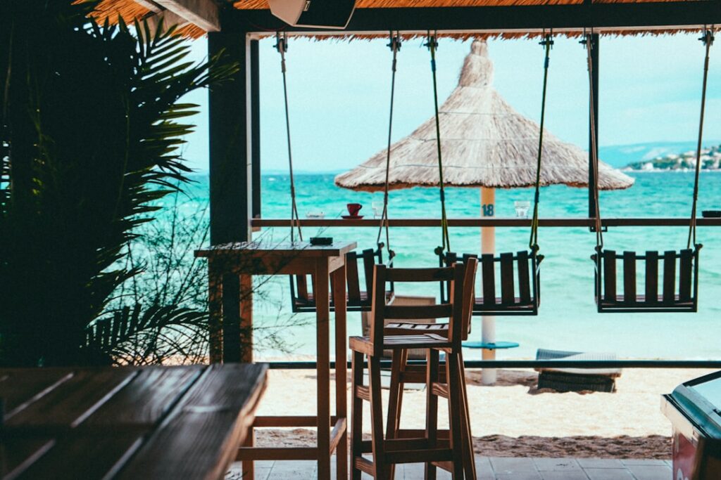 brown wooden beach lounge chair on beach during daytime